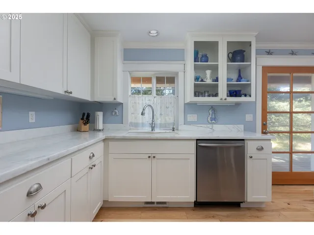 a kitchen with granite countertop white cabinets and window