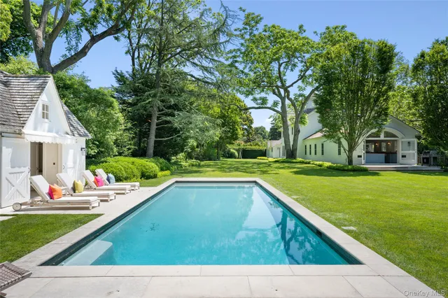 a view of house with swimming pool and outdoor seating