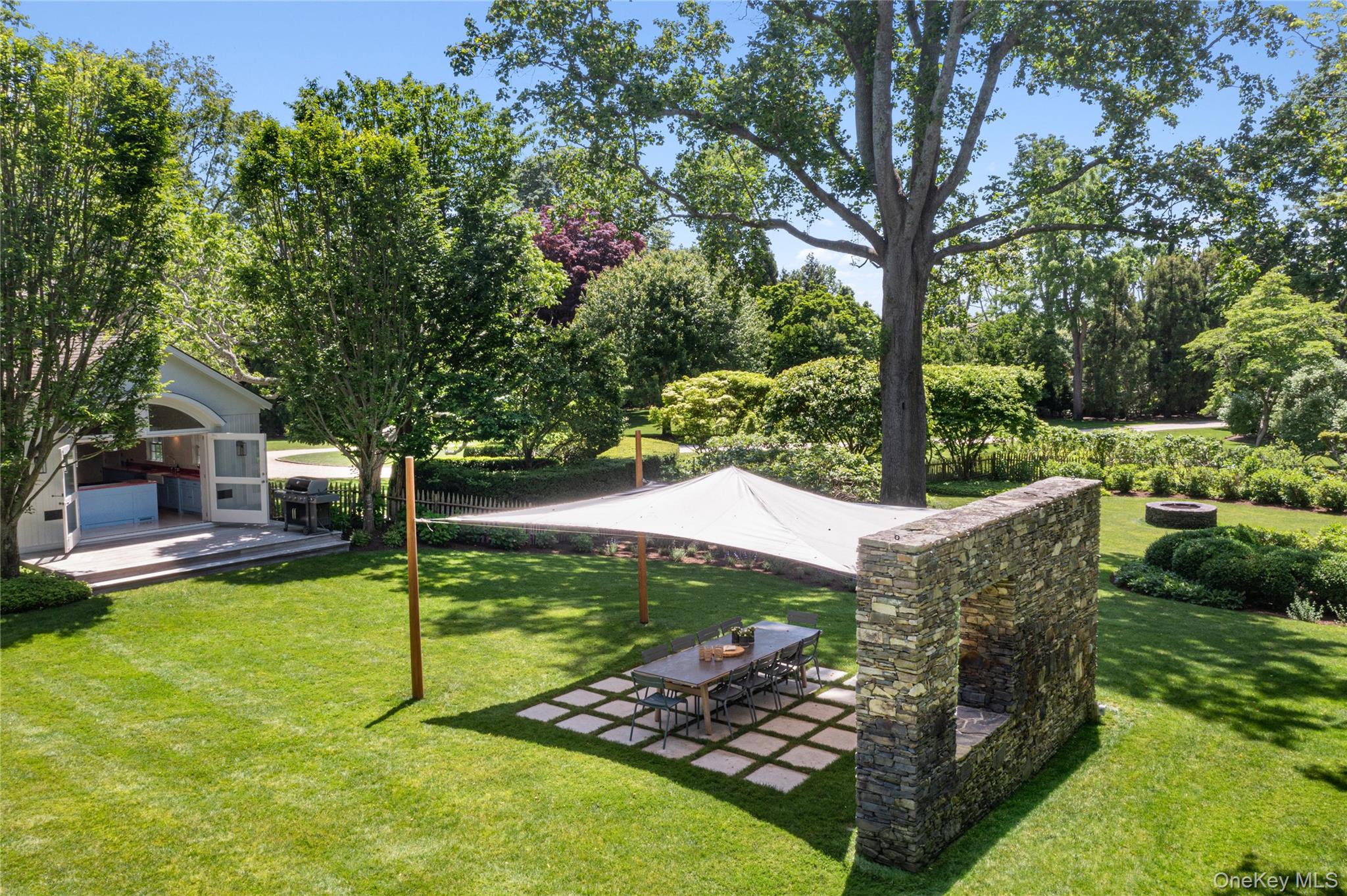 182 Church Lane Bridgehampton, NY 11932 - Photo 34 of 37 a view of a backyard with table and chairs potted plants and large tree