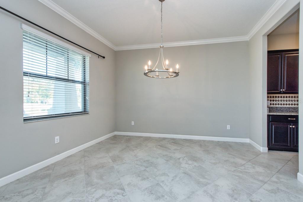 13315 Orca Sound Drive Riverview, FL 33579 - Photo 14 of 52 an empty room with chandelier fan and windows