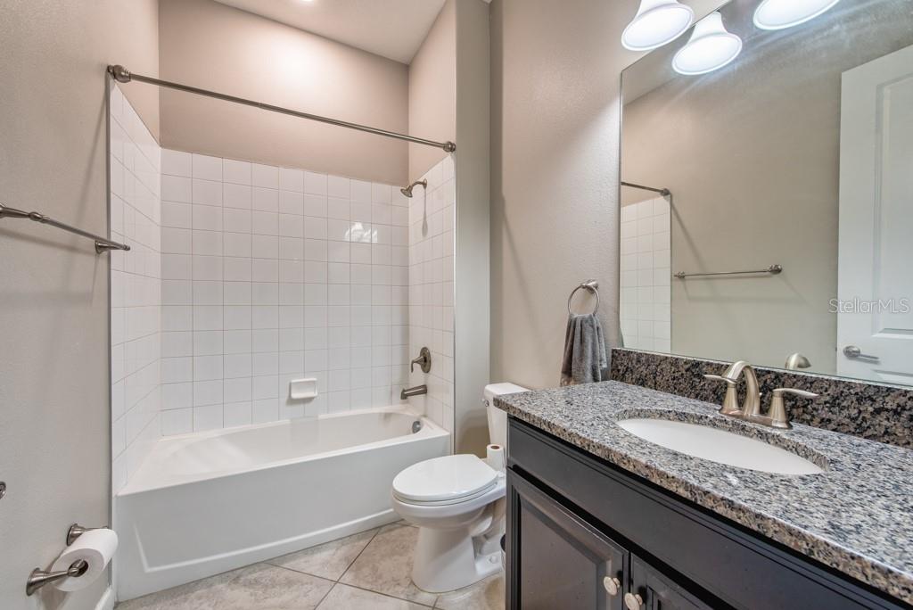 13315 Orca Sound Drive Riverview, FL 33579 - Photo 17 of 52 a bathroom with a granite countertop sink toilet mirror and shower