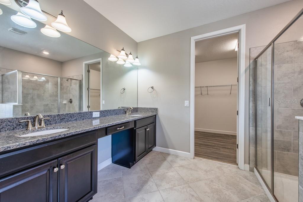 13315 Orca Sound Drive Riverview, FL 33579 - Photo 22 of 52 a bathroom with a granite countertop sink a mirror and a shower