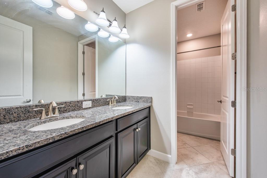 13315 Orca Sound Drive Riverview, FL 33579 - Photo 31 of 52 a bathroom with a granite countertop sink a light fixture and a mirror