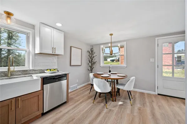 a kitchen with granite countertop white cabinets stove and sink