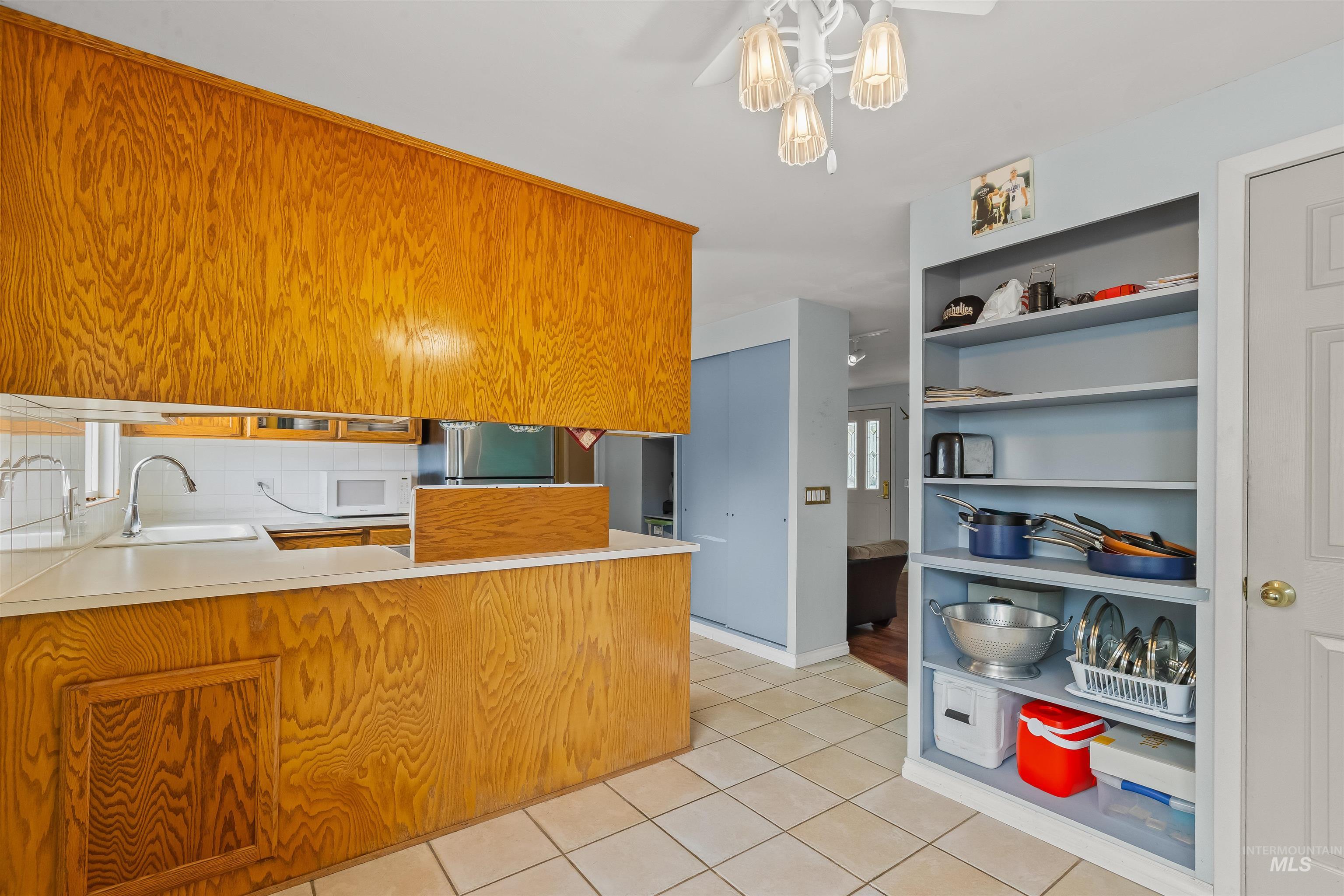 3620 18th Street Lewiston, ID 83501 - Photo 7 of 32 Kitchen featuring wood-finish cabinetry, solid surface countertops, a ceramic tile floor, and a drop-in sink with a gooseneck faucet