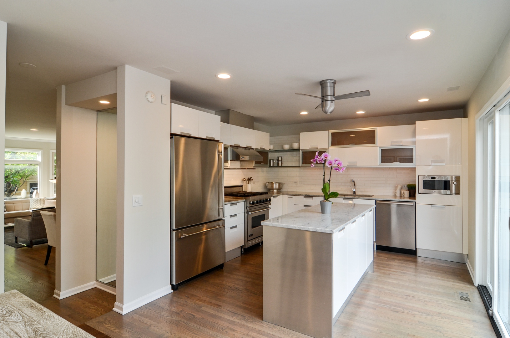 1014 West Grace Street Chicago, IL 60613 - Photo 9 of 24 a kitchen with stainless steel appliances granite countertop a refrigerator oven a sink dishwasher and white cabinets with wooden floor