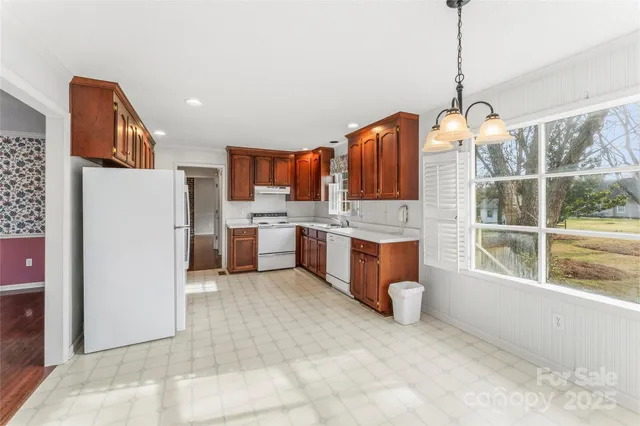 a open kitchen with stainless steel appliances granite countertop a refrigerator a sink a stove top oven a counter space and cabinets