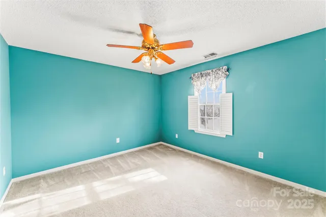 a view of a room with a ceiling fan and window