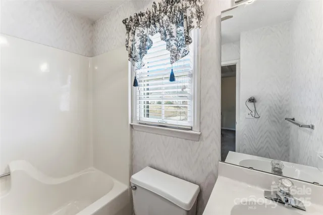 a bathroom with a tub sink and window