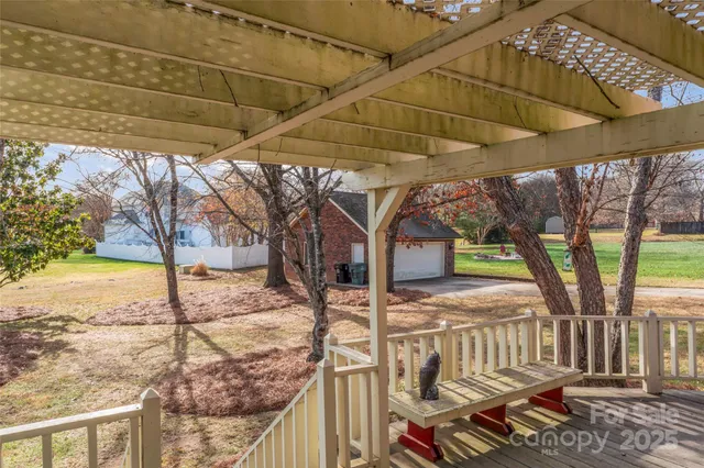 a view of a patio with a table chairs fire pit and wooden fence