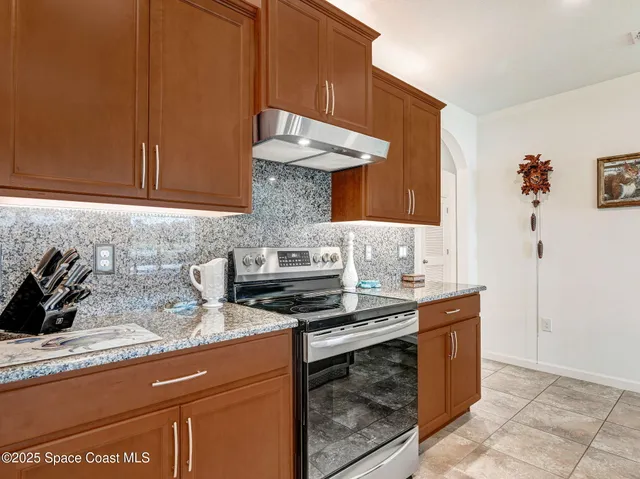 a large kitchen with stainless steel appliances granite countertop a stove and a sink
