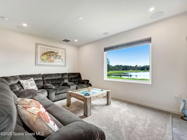 a bed sitting in a spacious bedroom next to a window