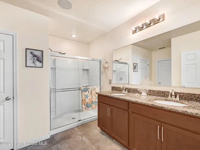 a bathroom with a granite countertop sink toilet and shower