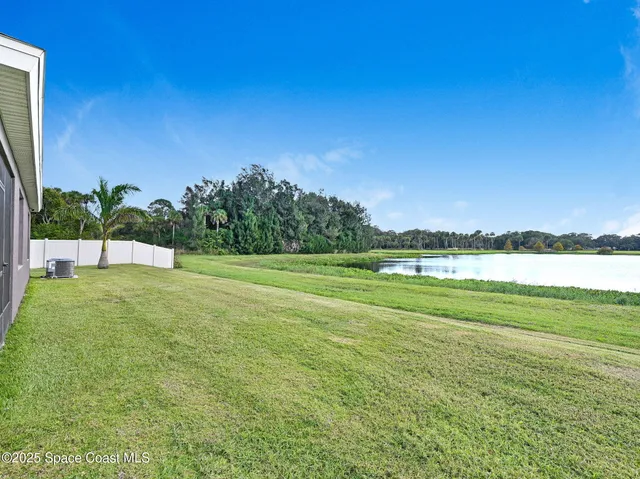 a front view of a house with a yard and lake view