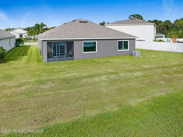 an aerial view of a house with a garden and lake view