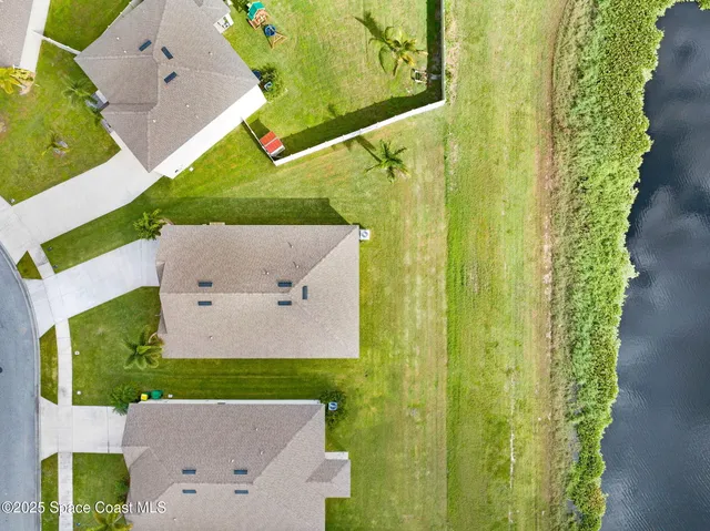 an aerial view of a house with outdoor space and a lake view