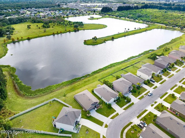 an aerial view of a house with outdoor space and a lake view