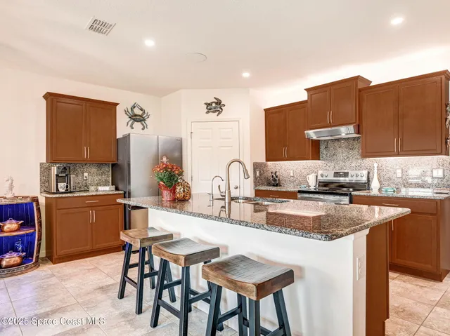 a kitchen with stainless steel appliances granite countertop a sink stove and cabinets