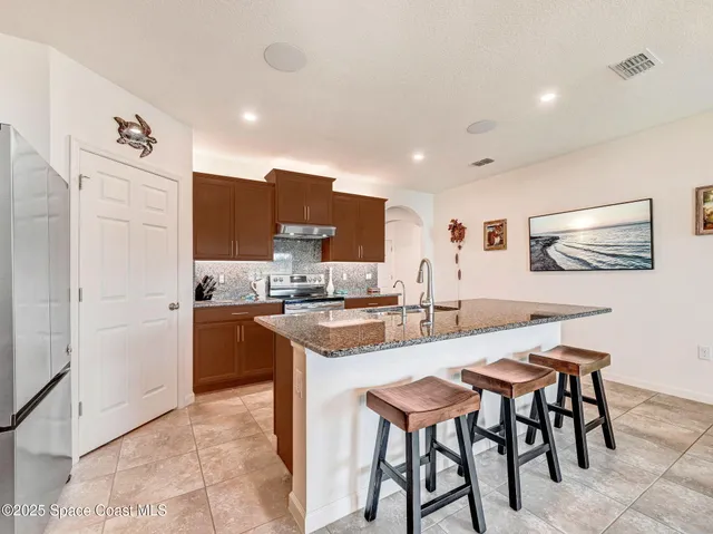 a kitchen with stainless steel appliances granite countertop a stove refrigerator and cabinets