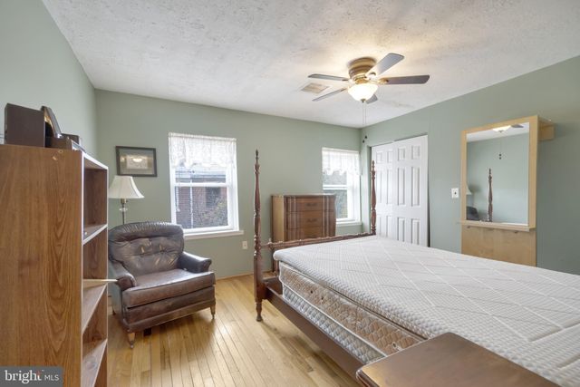 a bedroom with a bed couch and windows