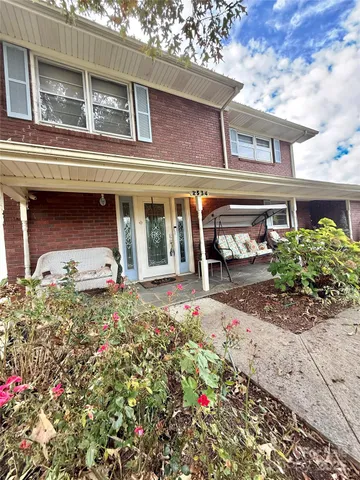 a view of swimming pool with seating area and trees in the background