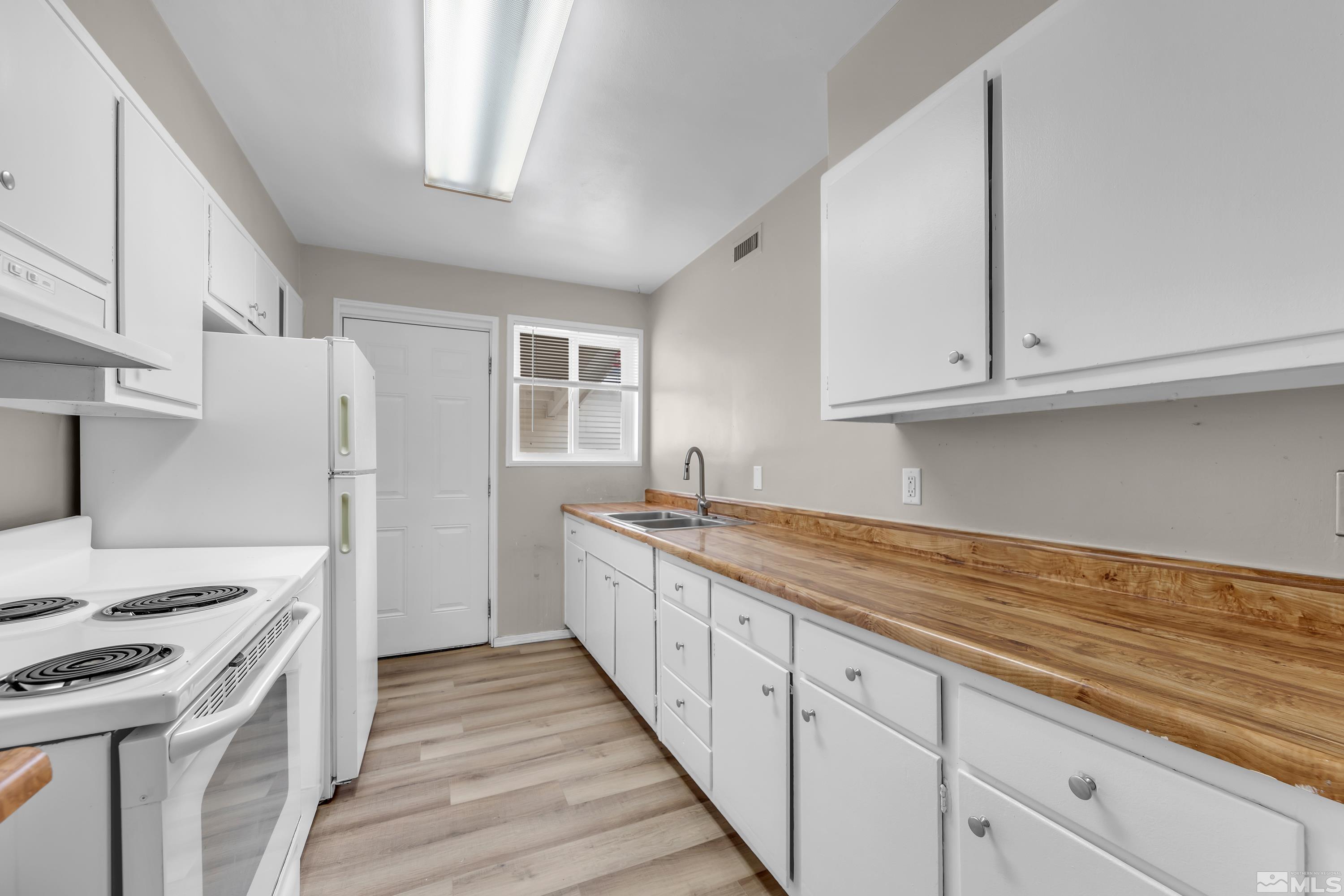 12190 Himalaya Street Reno, NV 89506 - Photo 11 of 34 a kitchen with granite countertop white cabinets and white appliances