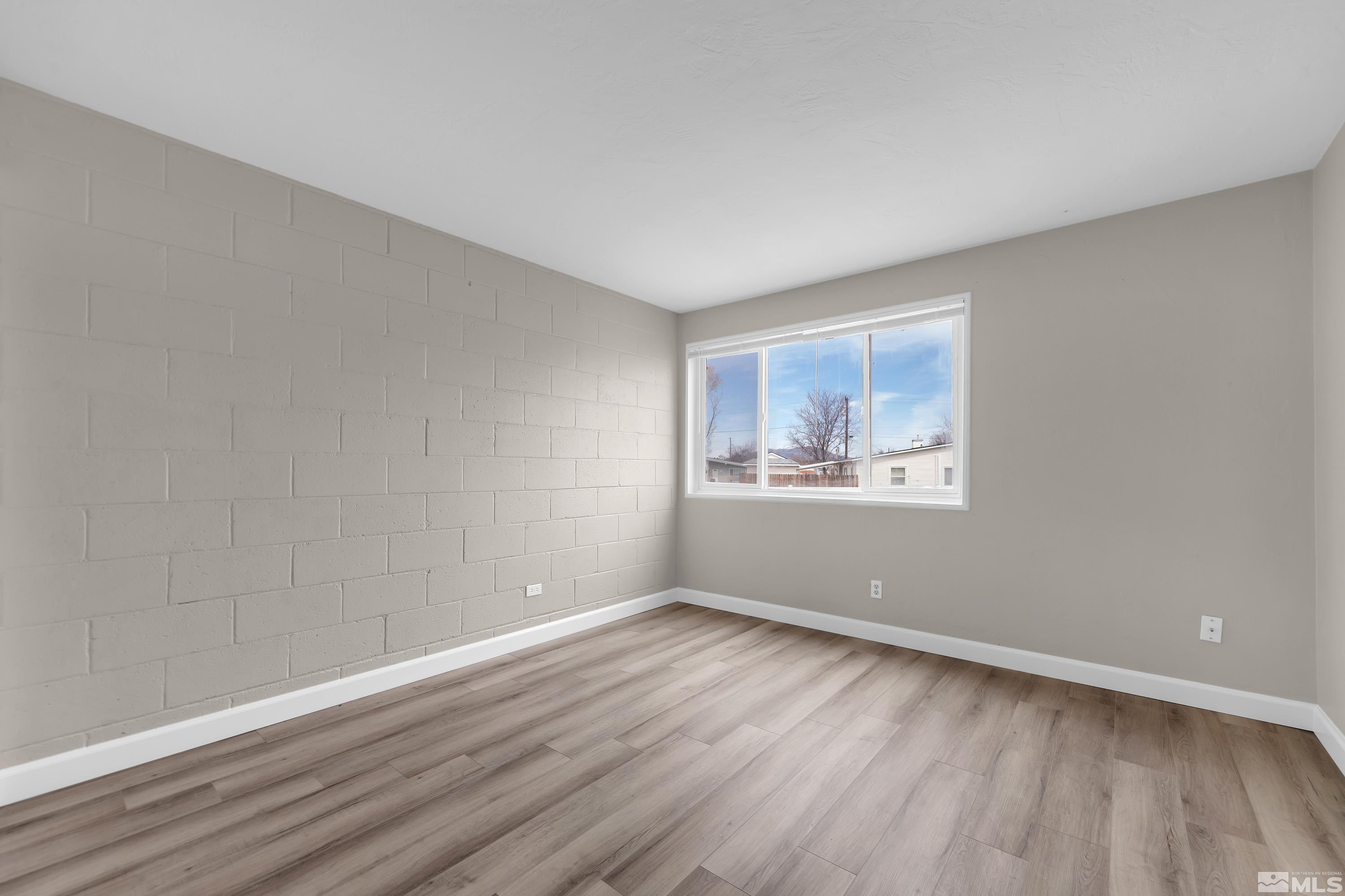 12190 Himalaya Street Reno, NV 89506 - Photo 14 of 34 a view of an empty room with wooden floor and a window