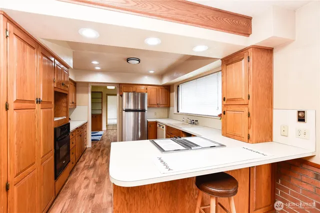 a large kitchen with a table chairs and refrigerator