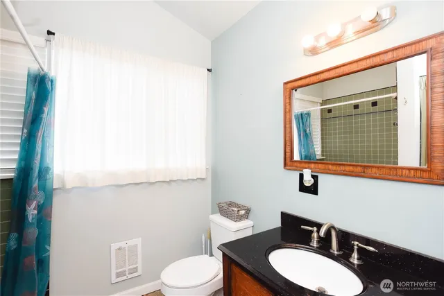 a bathroom with a toilet a sink and mirror
