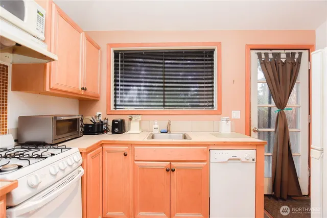 a kitchen with stainless steel appliances a stove a sink refrigerator and a microwave