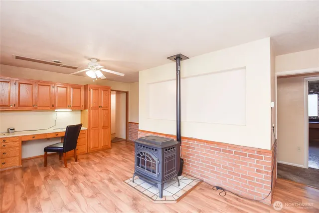 a living room with couches bookshelf and a appliances with wooden floor