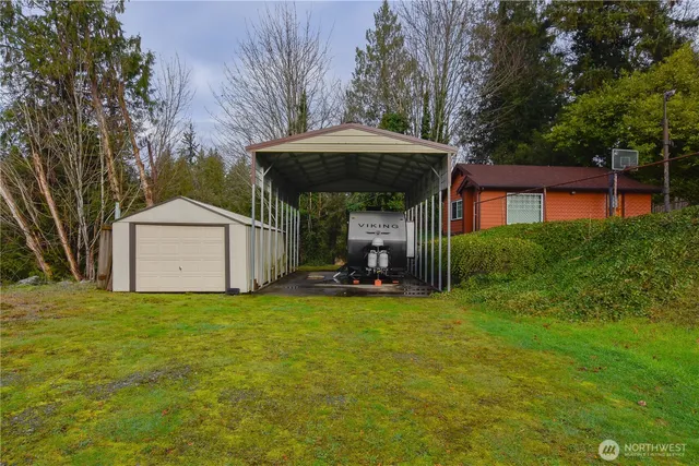 a view of a house with backyard and trees