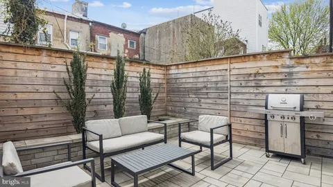a backyard of a house with sofas fire pit and outdoor seating
