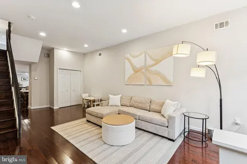 a living room with furniture and a wooden floor