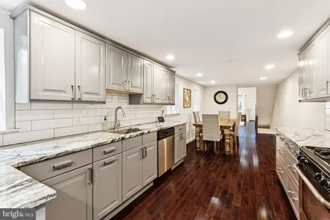 a kitchen with stainless steel appliances granite countertop sink stove top oven and cabinets