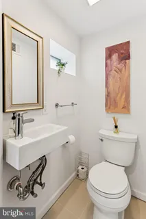 a bathroom with a toilet a sink and mirror