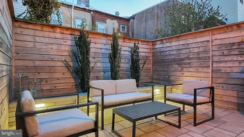 a backyard of a house with barbeque oven table and chairs