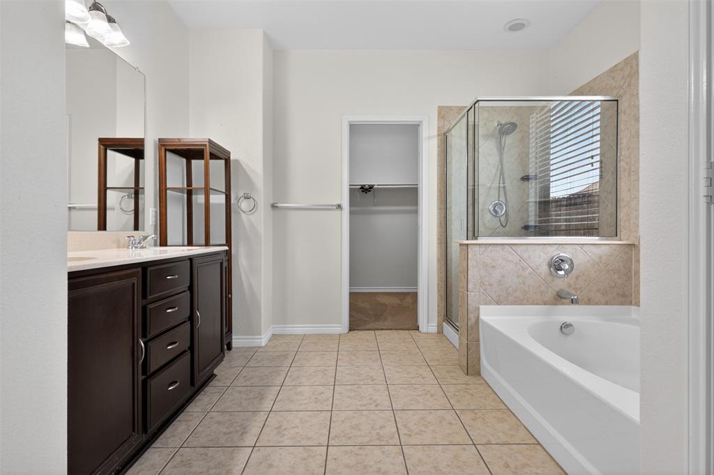 8728 Maple Ridge Trail Fort Worth, TX 76244 - Photo 21 of 40 Bathroom featuring a dark wood-finish vanity with a light-toned countertop, a frameless glass-enclosed shower, a built-in bathtub, and neutral-toned floor tiling