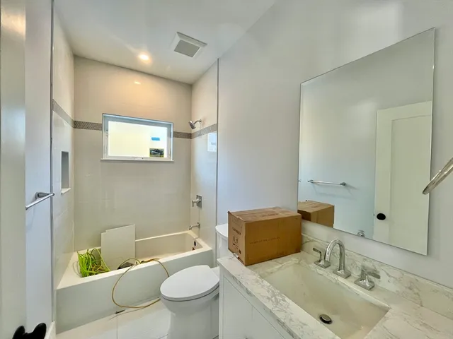 a bathroom with a granite countertop sink toilet and shower
