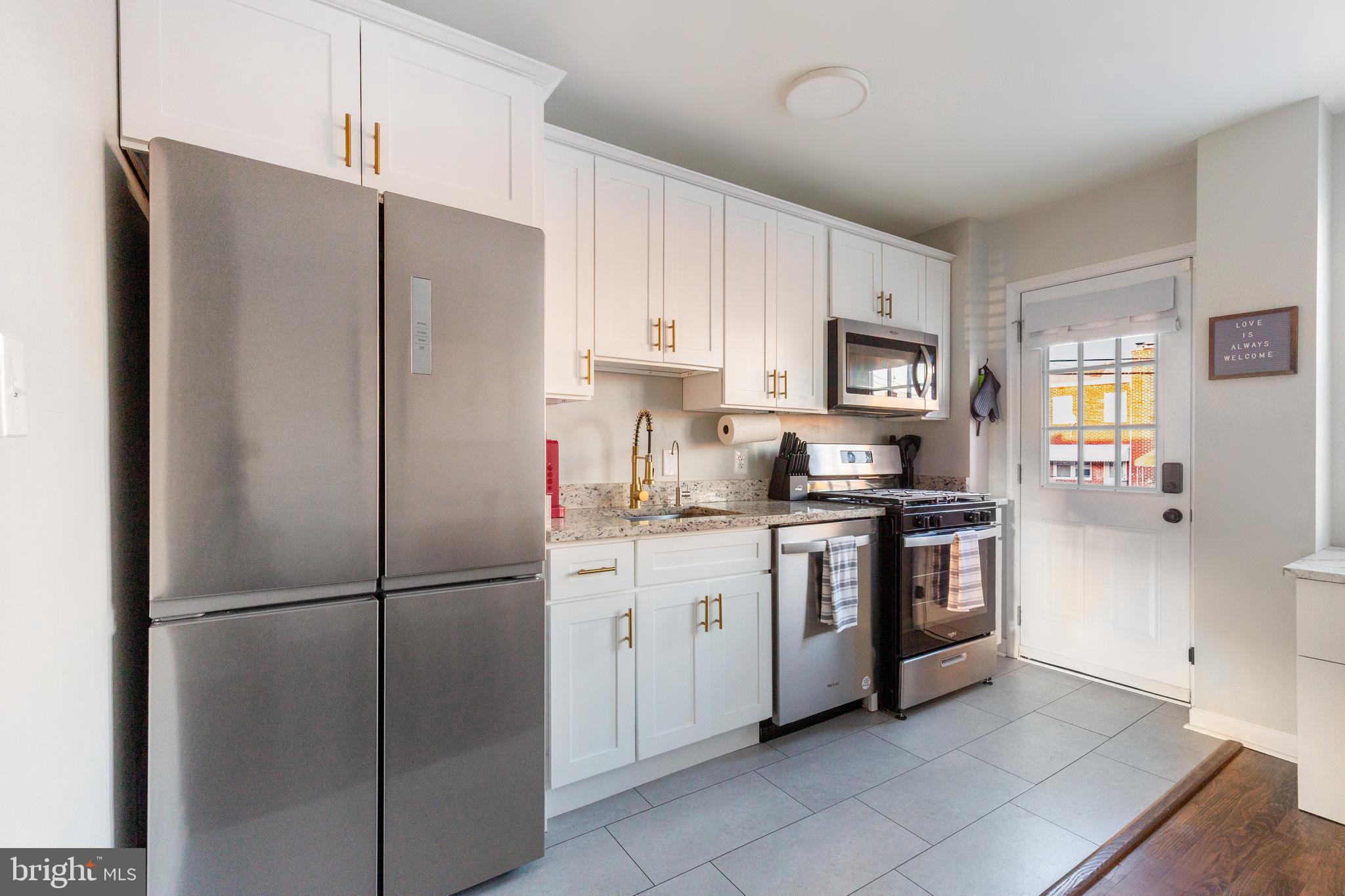 413 Imla Street Baltimore, MD 21224 - Photo 16 of 38 a kitchen with stainless steel appliances cabinets a refrigerator and a stove top oven