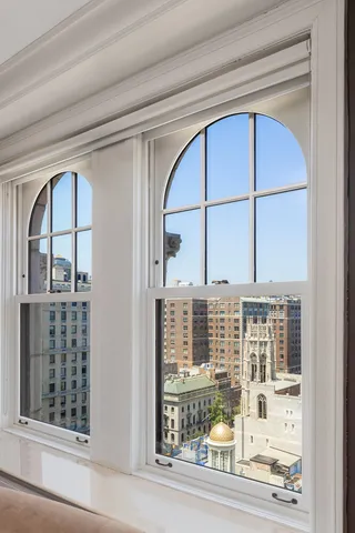 a view of a hallway with wooden floor and a cabinet