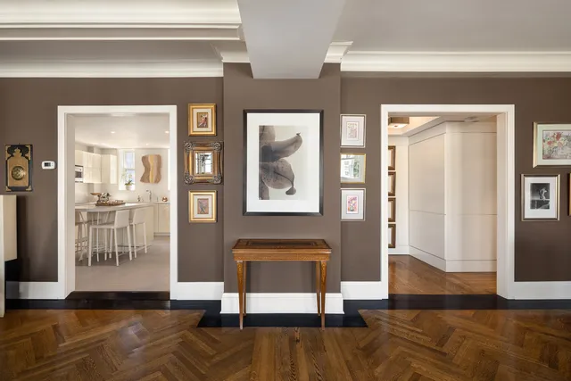 a view of hallway with livingroom and wooden floor