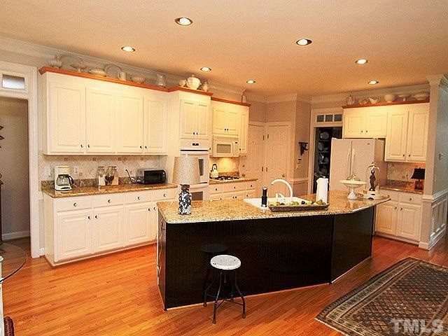 5805 Stone Spring Road Raleigh, NC 27613 - Photo 6 of 24 Updated island kitchen with tile backsplash, gas cooktop, granite, double oven, and separate desk area. Kitchen is open to the family room. Kitchen