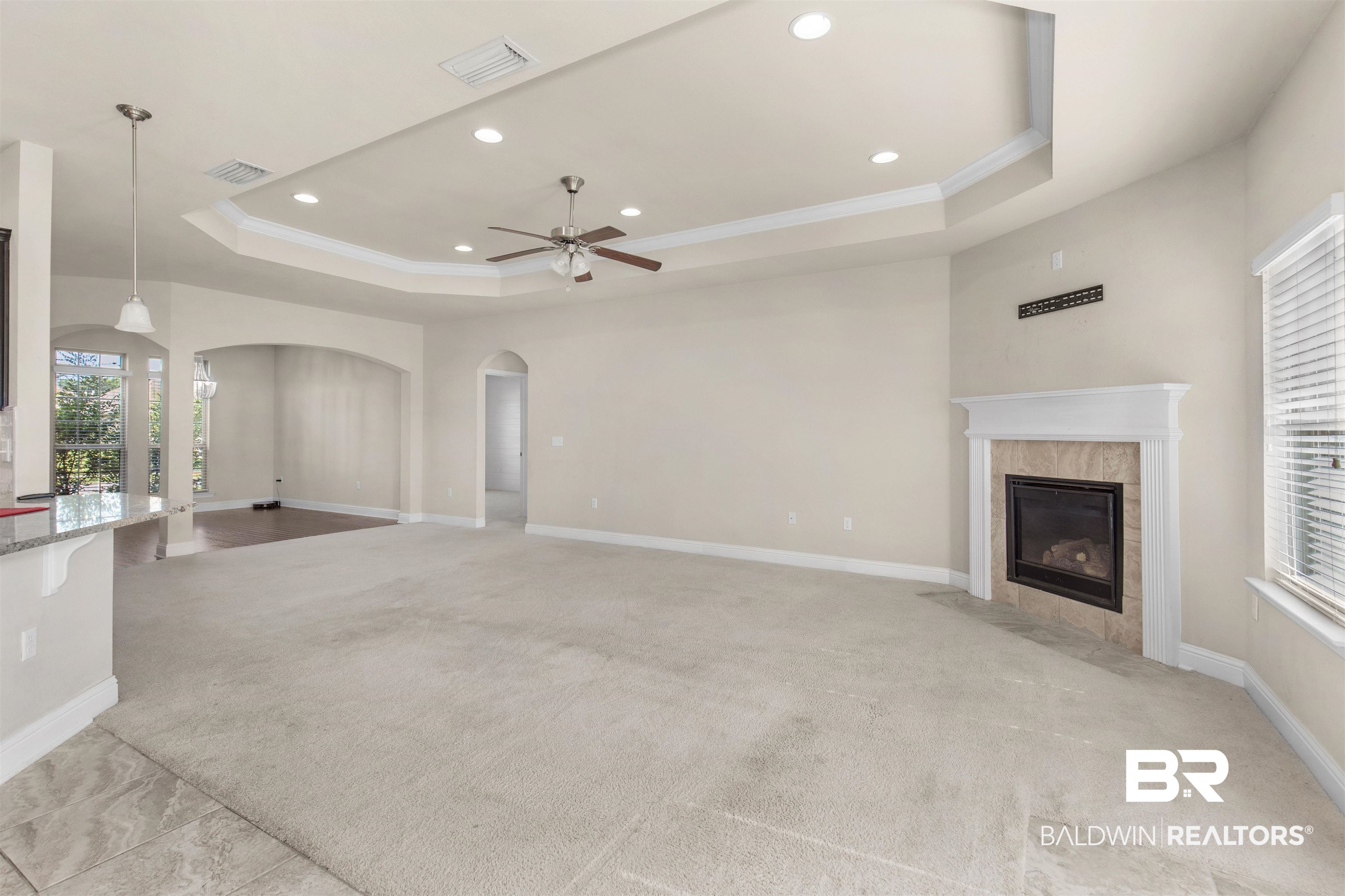 122 Open Field Drive Fairhope, AL 36532 - Photo 5 of 27 Unfurnished living room featuring a fireplace, ceiling fan, a raised ceiling, and light colored carpet