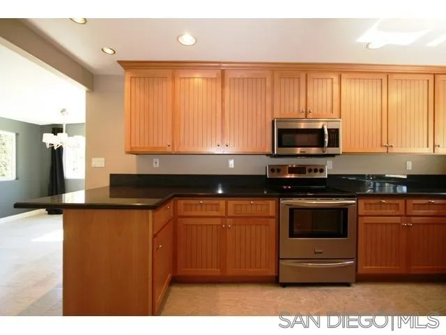 5964 Dehesa Road El Cajon, CA 92019 - Photo 6 of 13 a kitchen with stainless steel appliances granite countertop a stove a sink and a microwave