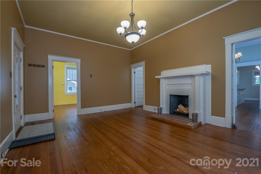 145 Pine Street Rutherfordton, NC 28139 - Photo 14 of 35 a view of an empty room with wooden floor a fireplace and a window