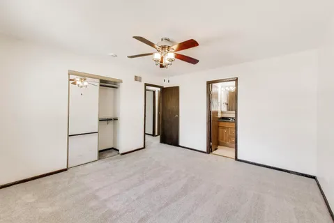 a view of a livingroom with a ceiling fan and refrigerator