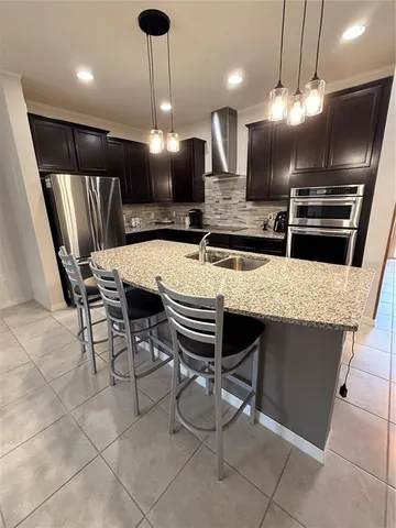 a kitchen with a table a refrigerator and chairs