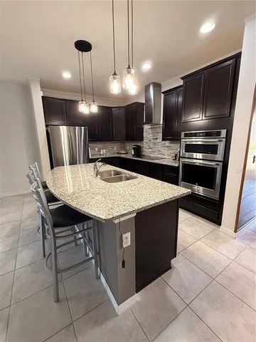 a kitchen with granite countertop a sink and a refrigerator