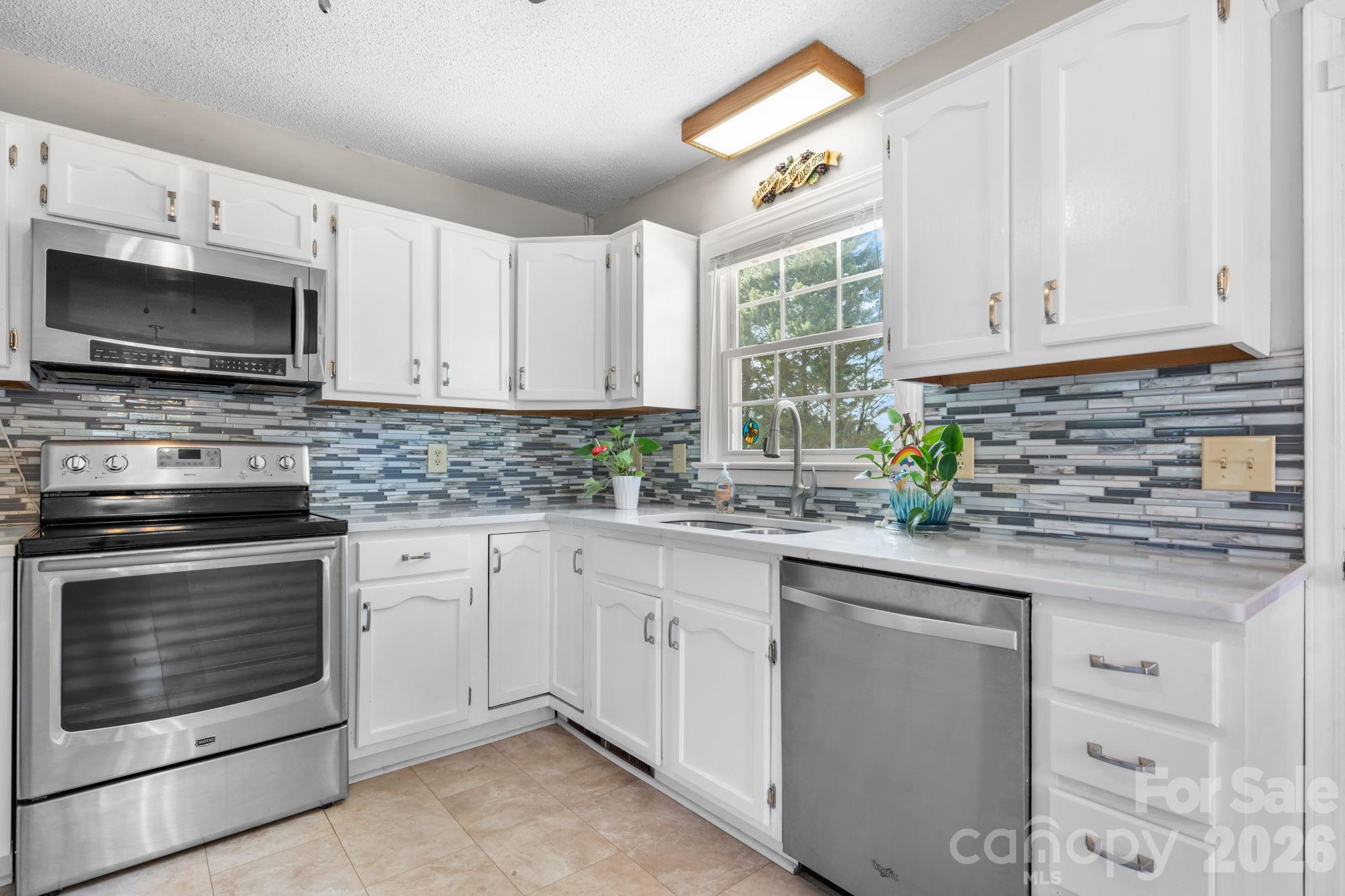 65 Pinewood Road Granite Falls, NC 28630 - Photo 12 of 42 a kitchen with granite countertop white cabinets white stainless steel appliances and a sink